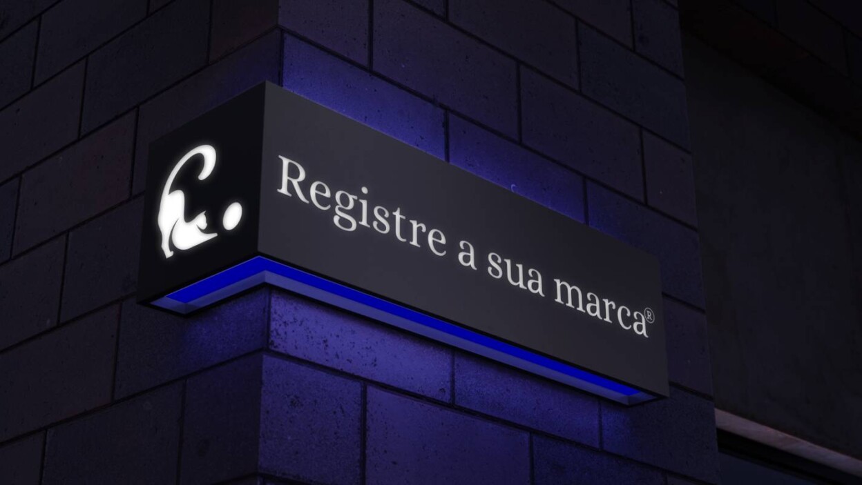 Em um fundo de parede escura, com luz neon azul refletindo nela, há uma fachada de prédio, com o logotipo minimalista da Clarêncio à esquerda e a frase "Registre a sua marca" junto do símbolo de registro de marca, à direita.